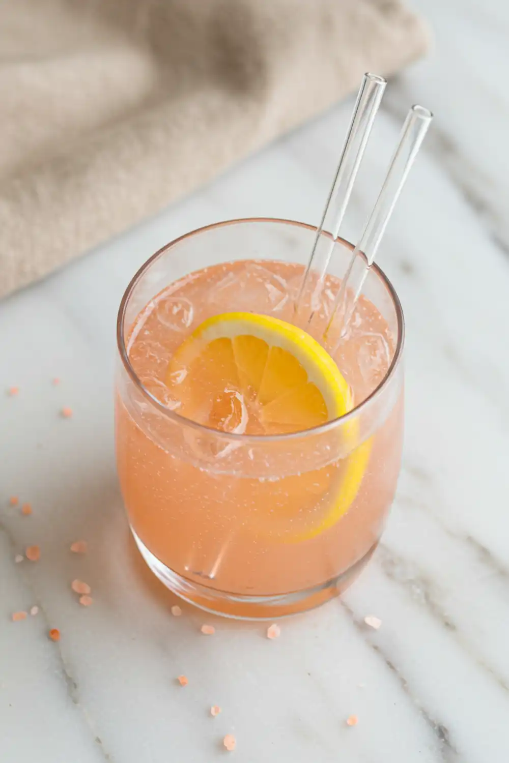 Pink Salt and Apple Cider Vinegar Tonic: My Daily Digestive Reset 1 Close-up top-down view of the finished Pink Salt and Apple Cider Vinegar Tonic in a clear glass with subtle wear, garnished with a fresh lemon slice, looking natural and home-prepared.